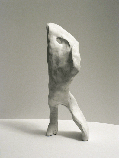 An animation of a totally abstract cast plaster scultpure that has a vertical stance.
