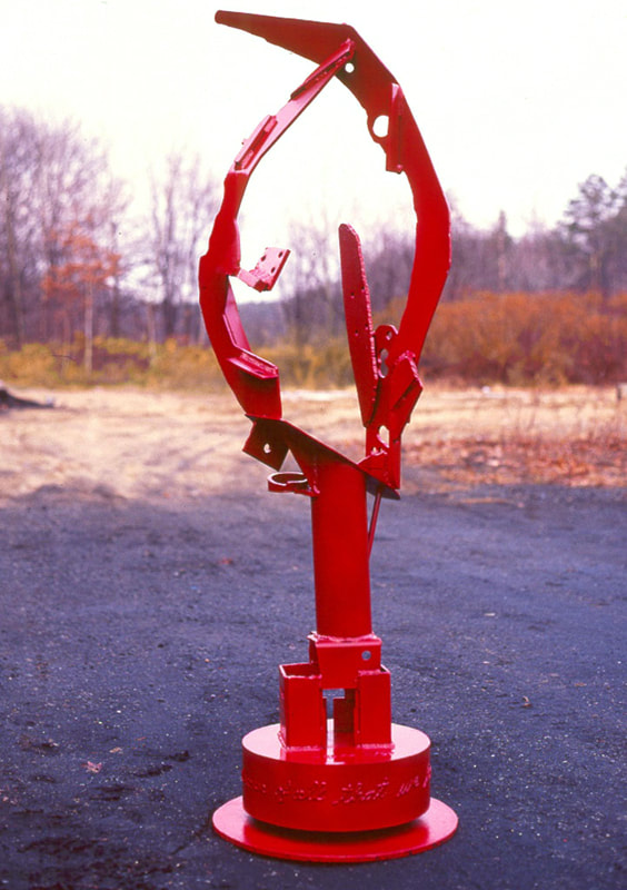 Outdoors, a red abstract sculpture with upright elements.
